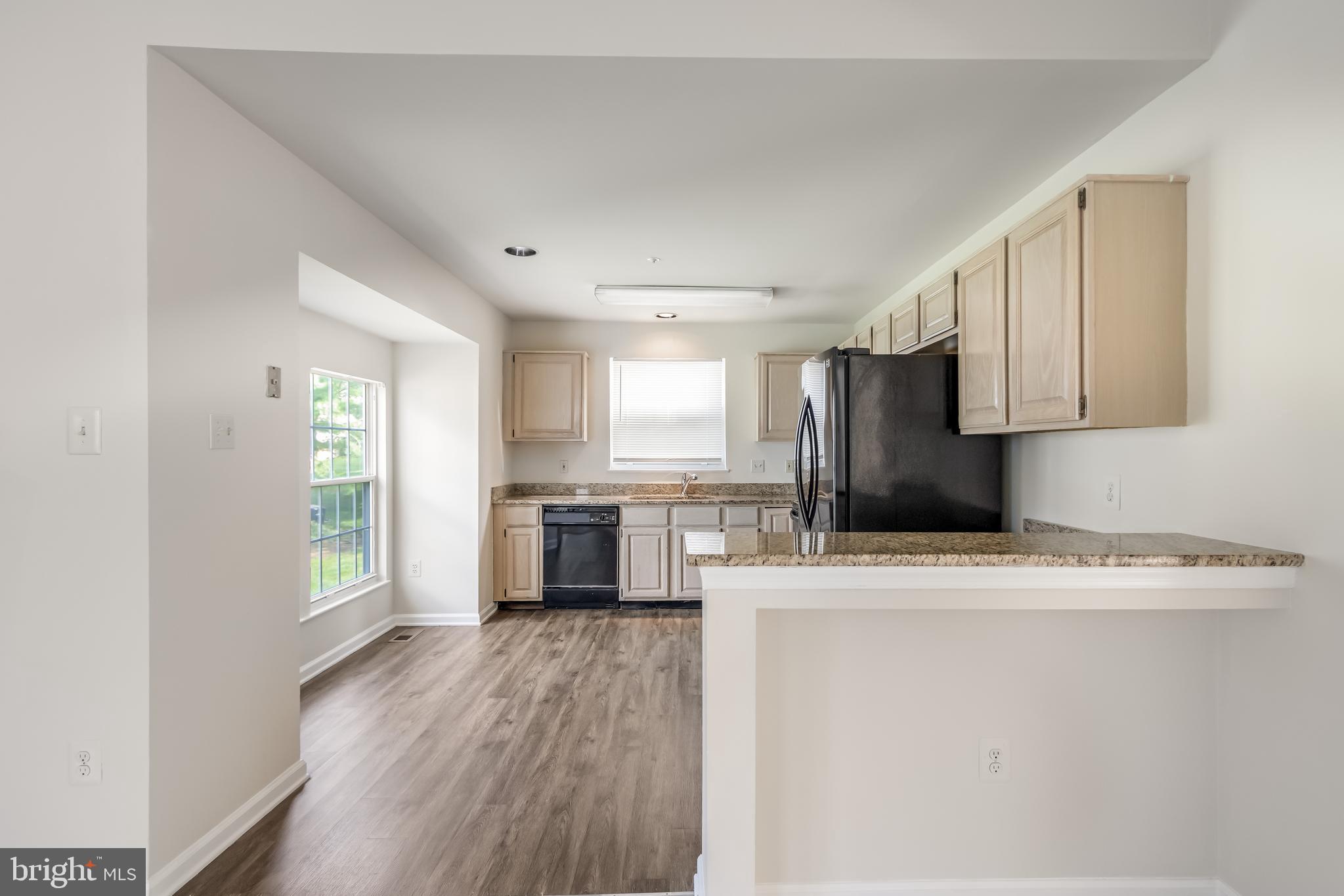936 Millponds Court Bowie, MD 20721 - Photo 12 of 57 a kitchen with stainless steel appliances granite countertop a refrigerator a stove top oven a sink and dishwasher with wooden floor