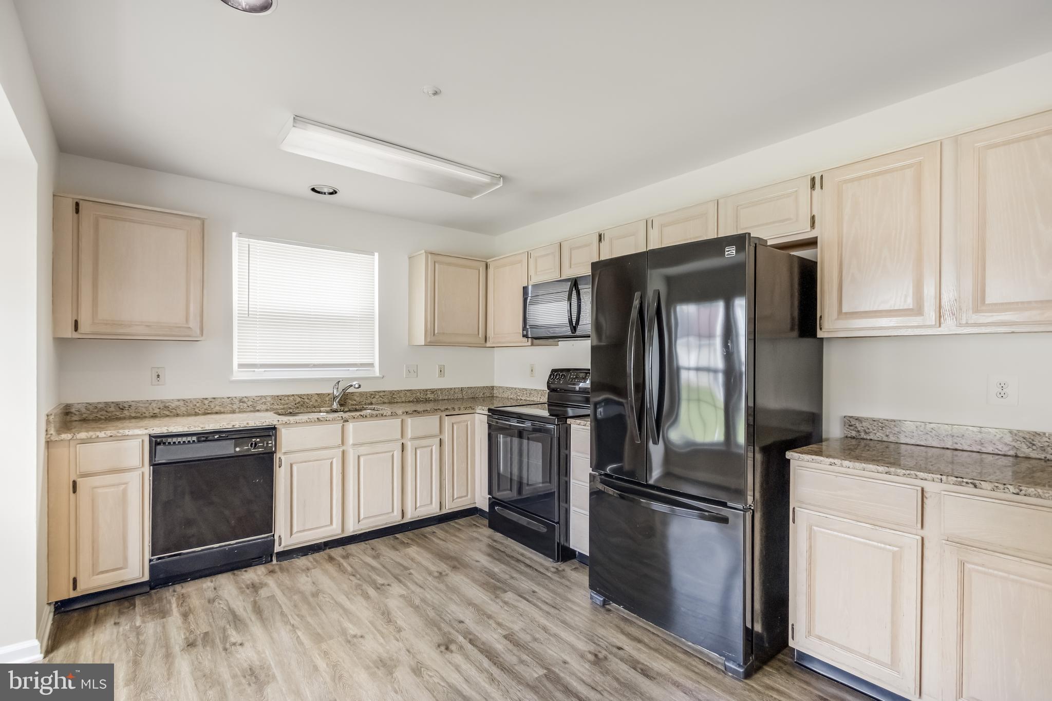 936 Millponds Court Bowie, MD 20721 - Photo 13 of 57 a kitchen with granite countertop stainless steel appliances a sink cabinets and a window