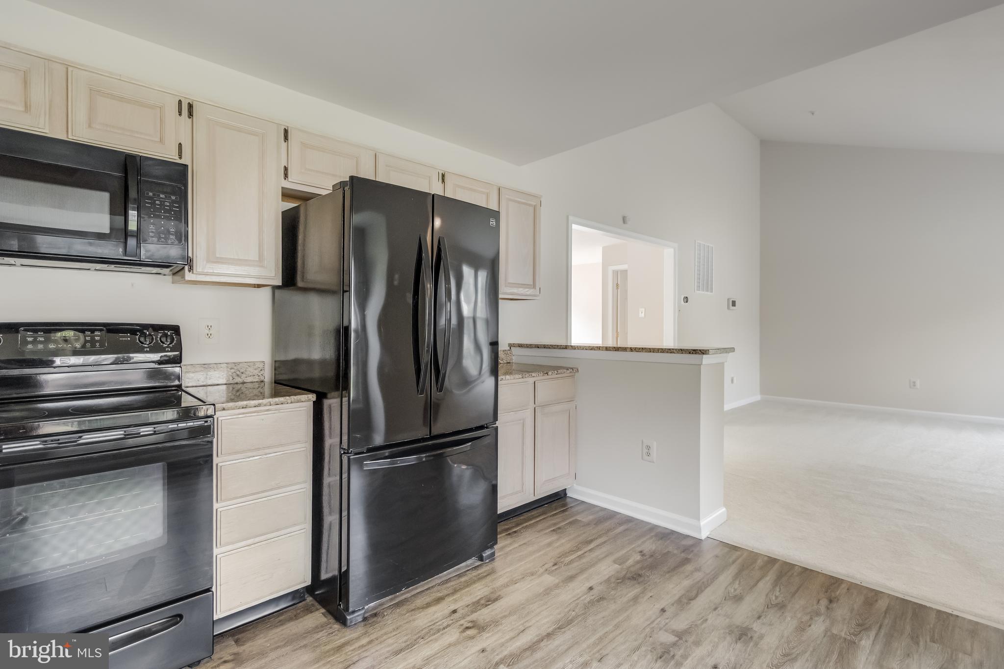 936 Millponds Court Bowie, MD 20721 - Photo 15 of 57 a kitchen with a refrigerator stove and white cabinets