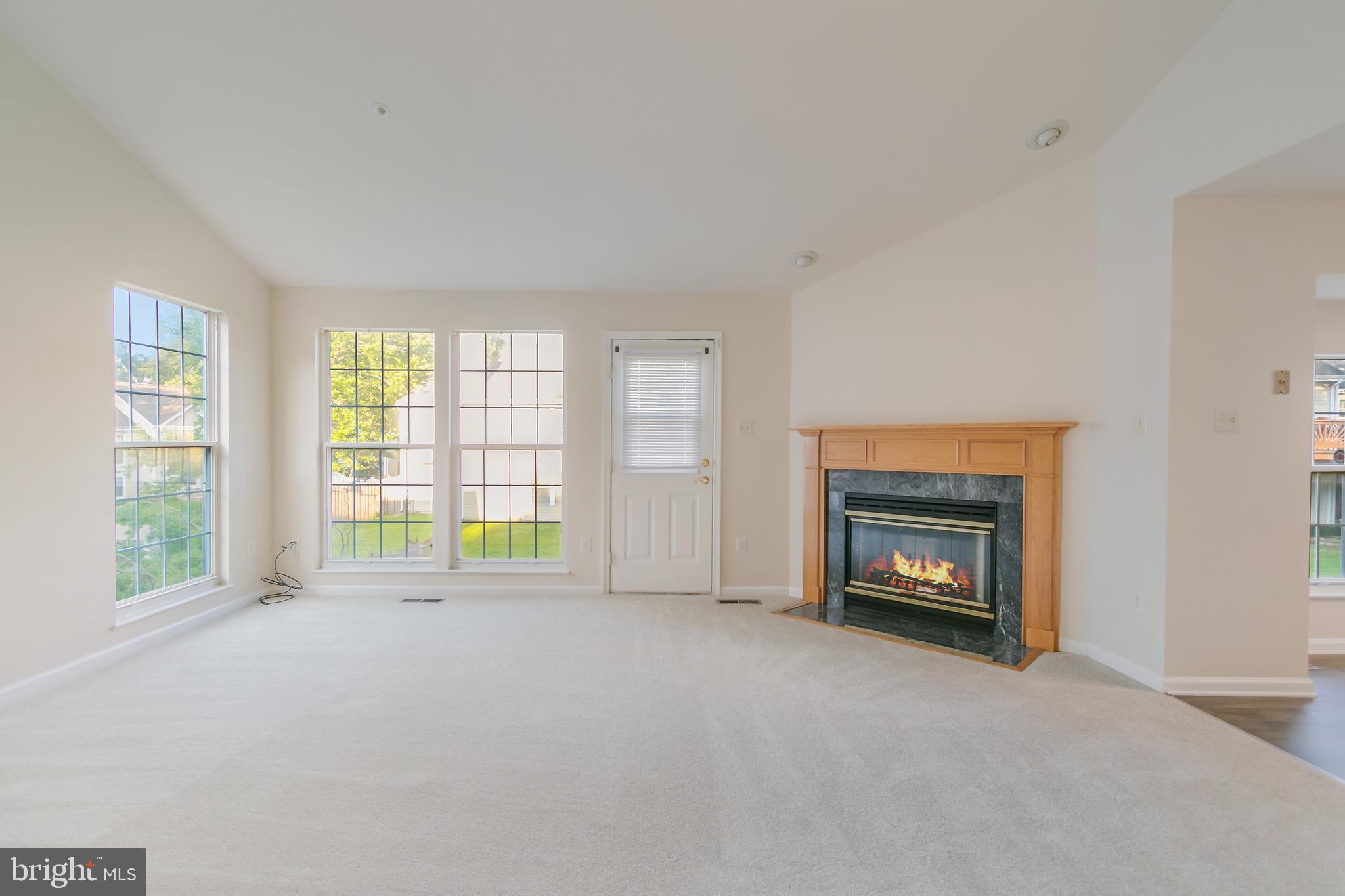 936 Millponds Court Bowie, MD 20721 - Photo 31 of 57 a view of an empty room with a fireplace and a window