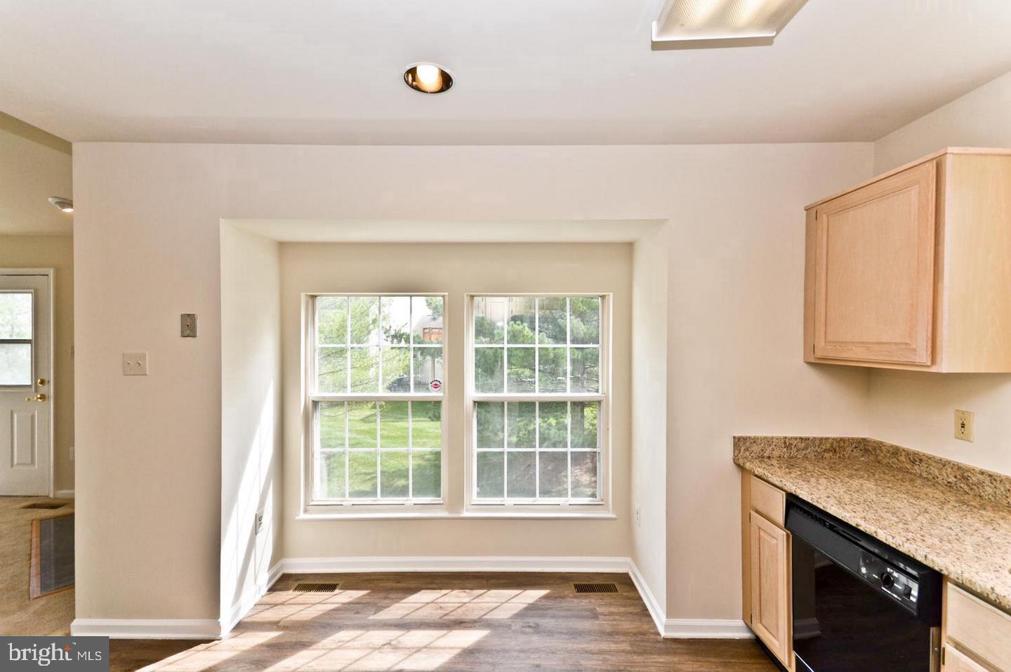 936 Millponds Court Bowie, MD 20721 - Photo 10 of 57 a view of an empty room with wooden floor and a window