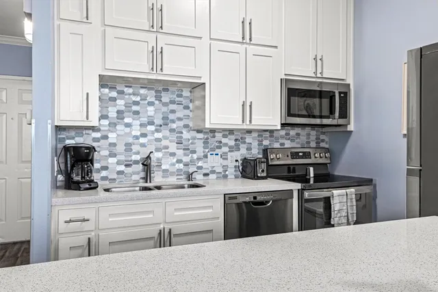 a kitchen with stainless steel appliances a stove sink microwave and cabinets