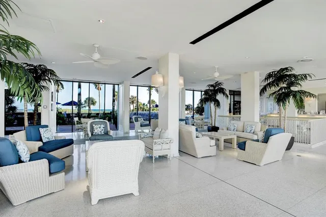 a living room with furniture and a large window with potted plants