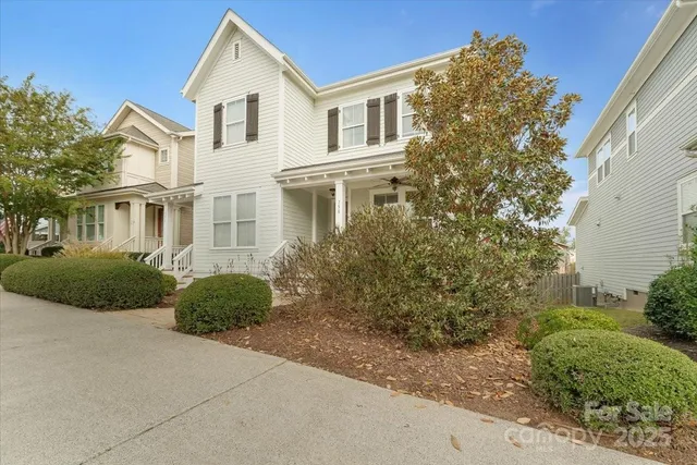 a view of a white house next to a yard