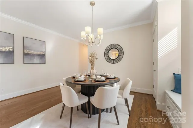 a dining room with wooden floor a chandelier a wooden table and chairs