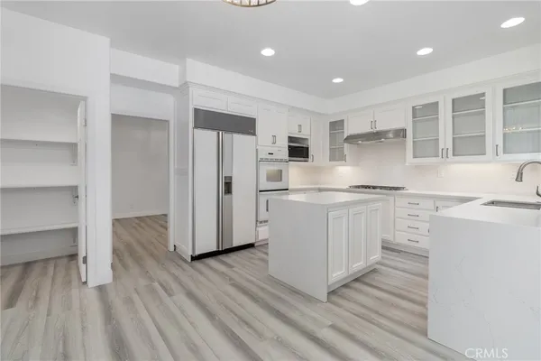 a kitchen with white cabinets and stainless steel appliances