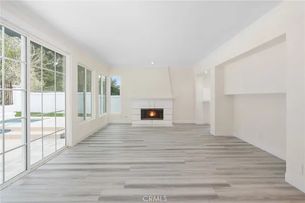 a view of empty room with wooden floor and fireplace