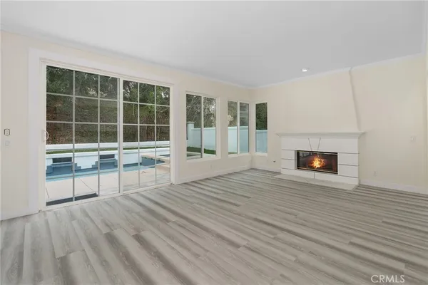 a view of empty room with wooden floor and fireplace