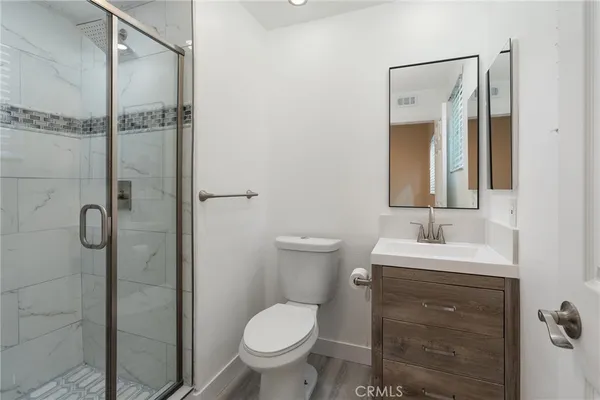 a bathroom with a toilet sink vanity and shower