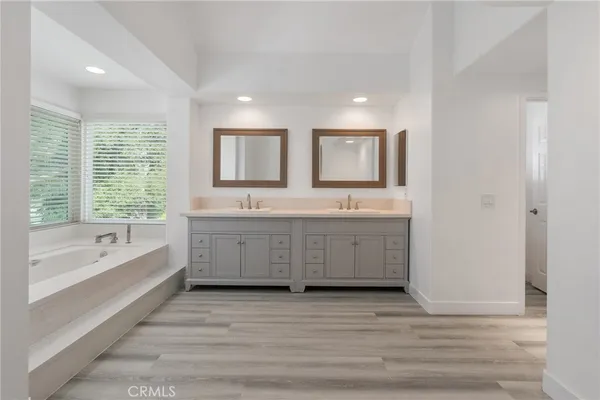 a bathroom with a sink mirror and a bathtub