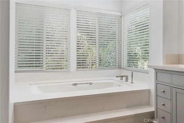 a bathroom with bathtub and window