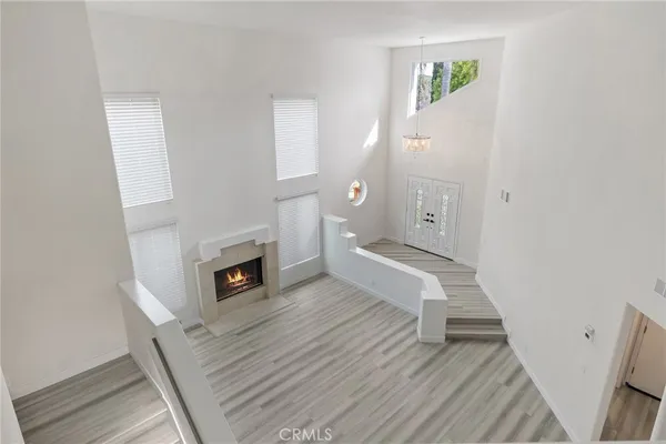a view of a livingroom with wooden floor and a fireplace