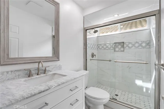 a bathroom with a granite countertop sink toilet and shower