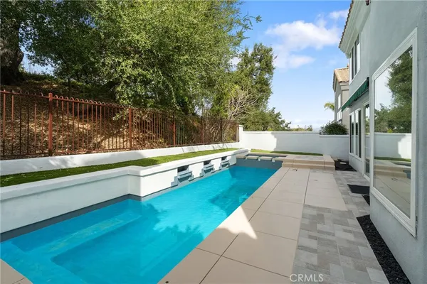 a view of swimming pool with a patio and a yard