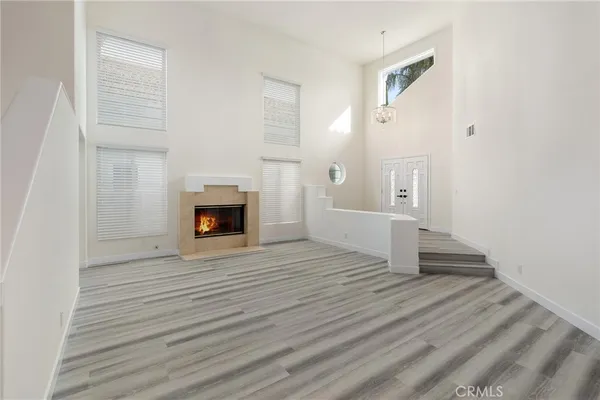 a view of a livingroom with wooden floor and a fireplace