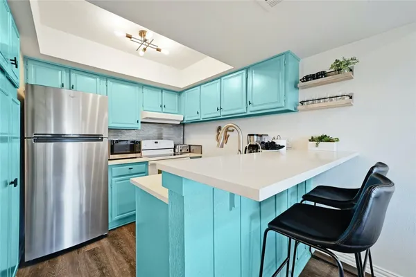 a kitchen with granite countertop a sink cabinets and stainless steel appliances