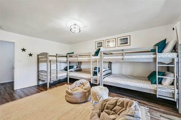 a view of a bedroom with wooden floor and windows