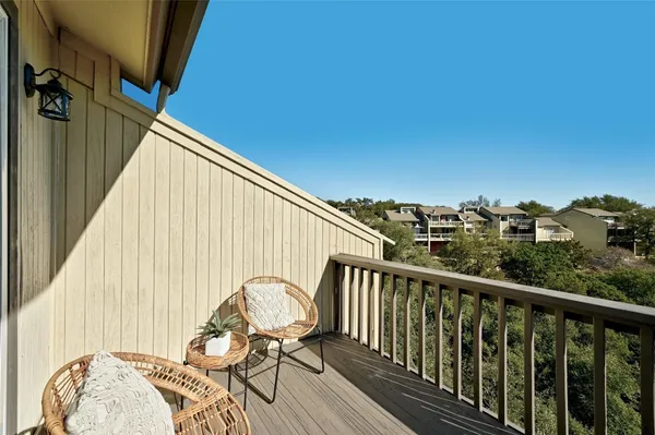 a view of balcony with wooden floor and fence