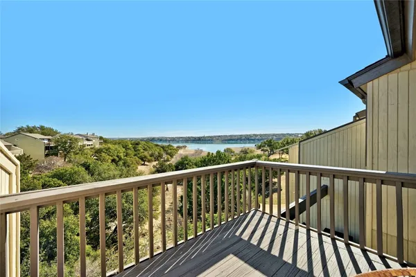 a view of a balcony with wooden floor and iron stairs