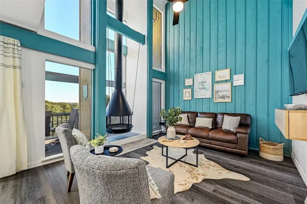 a living room with furniture floor to ceiling window and wooden floor