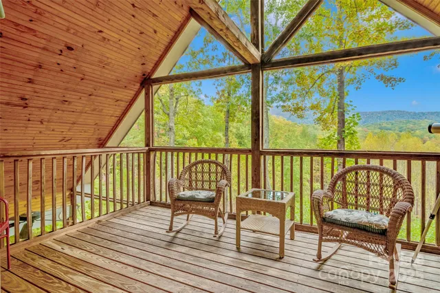 a view of a balcony with chairs and wooden floor
