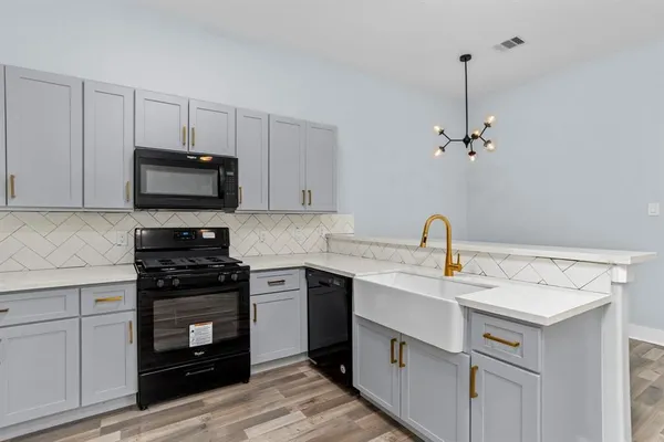 a kitchen with a sink stainless steel appliances and white cabinets