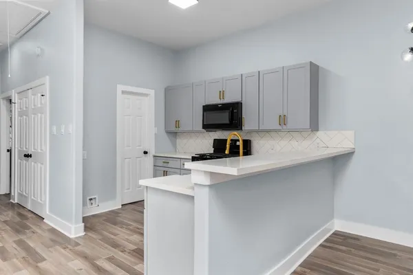 a kitchen with a appliances a sink and a microwave