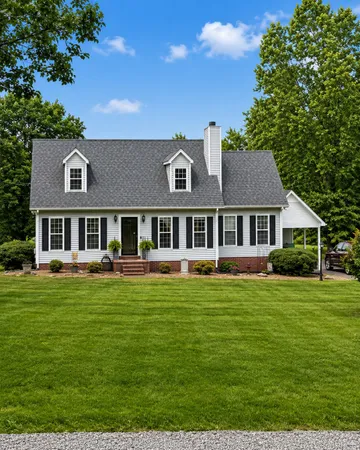 a view of a house with a big yard plants and large trees