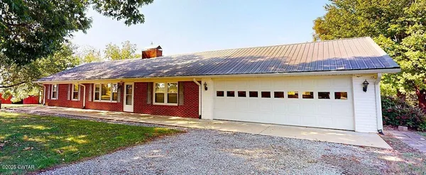 a front view of a house with a garden and yard