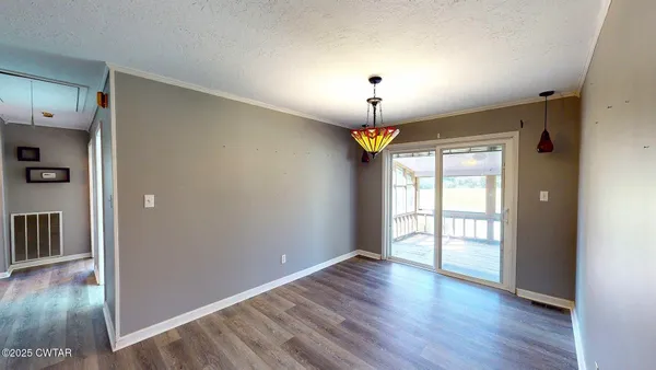 an empty room with wooden floor and window