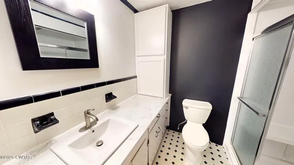a bathroom with a toilet sink and mirror