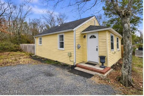 a view of a house with a yard and wooden fence