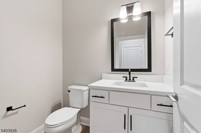 a bathroom with a toilet sink vanity and mirror