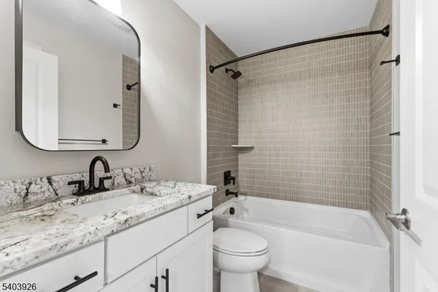 a bathroom with a granite countertop sink toilet mirror and shower