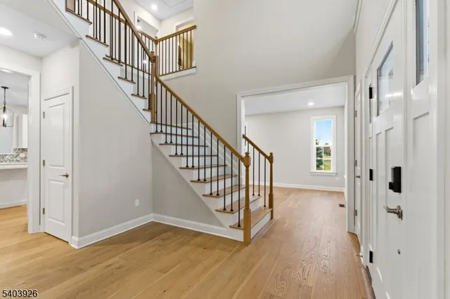 a view of a hallway with wooden floor and staircase