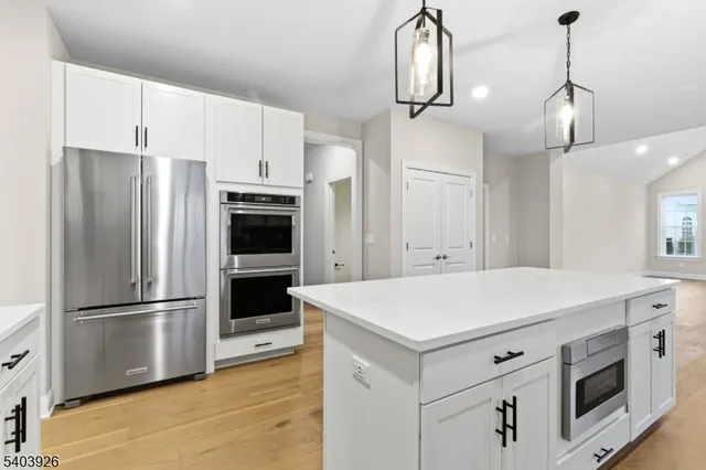 a kitchen with stainless steel appliances a refrigerator and a stove top oven