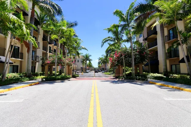 a row of palm trees in front of a house
