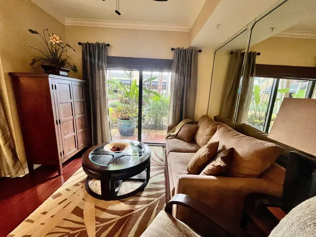 a living room with furniture a flat screen tv and a window