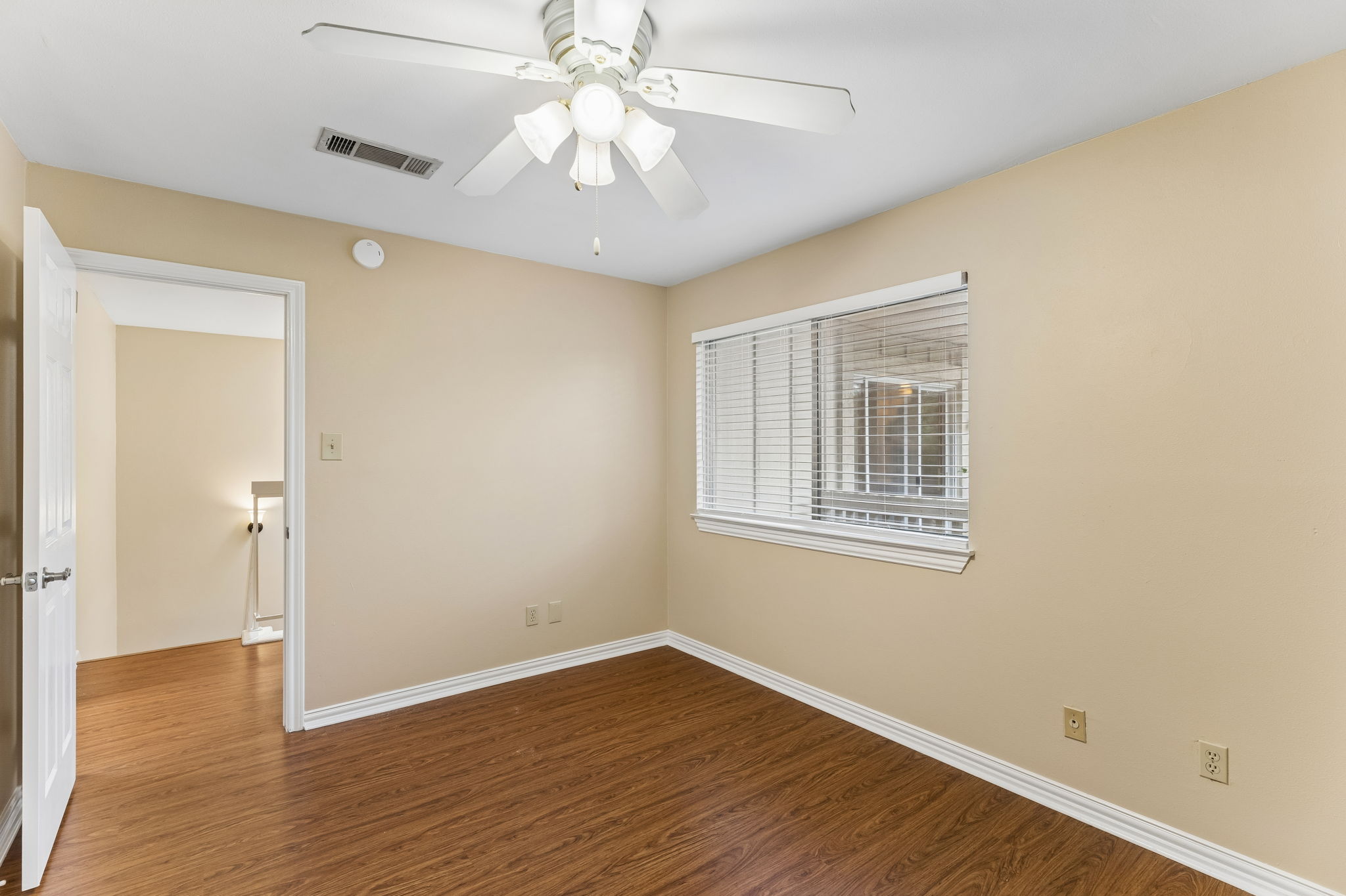 8340 Fathom Circle, Unit 103 Austin, TX 78750 - Photo 19 of 30 a view of an empty room with wooden floor and a window