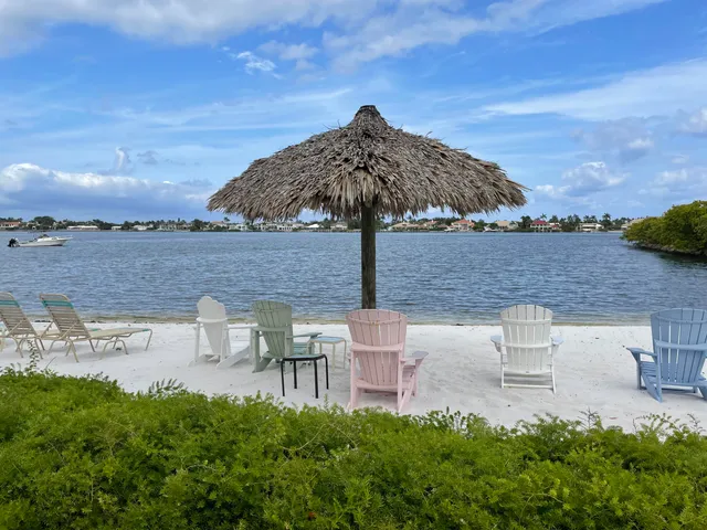 a view of a lake with table and chairs under an umbrella