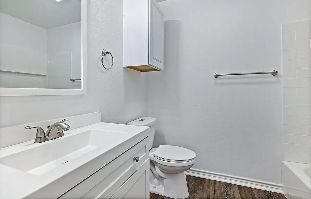 406 East Elm Street Denison, TX 75021 - Photo 13 of 21 a bathroom with a sink mirror vanity and toilet