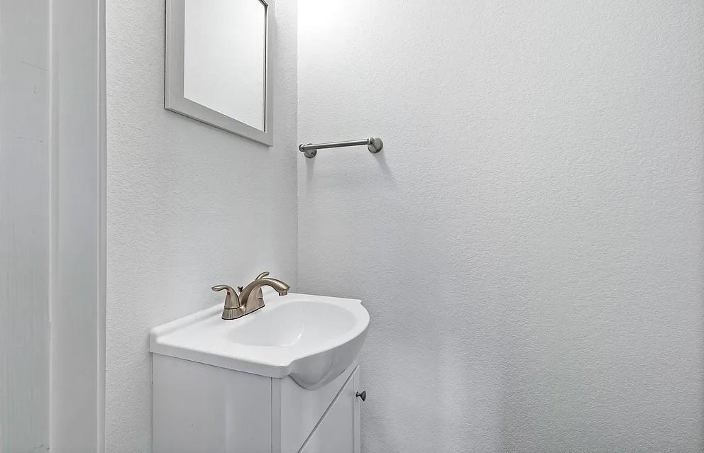406 East Elm Street Denison, TX 75021 - Photo 17 of 21 a bathroom with a sink and a mirror