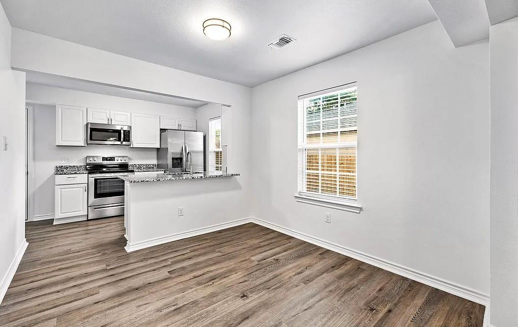 406 East Elm Street Denison, TX 75021 - Photo 7 of 21 a kitchen with wooden floors and appliances