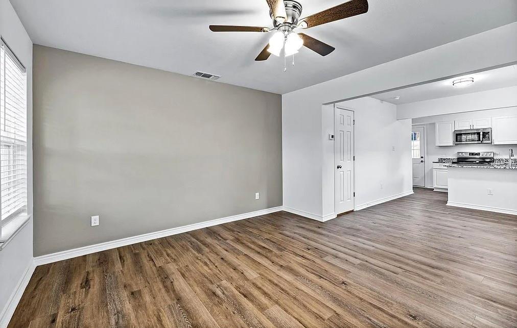 406 East Elm Street Denison, TX 75021 - Photo 9 of 21 wooden floor in an empty room with a window