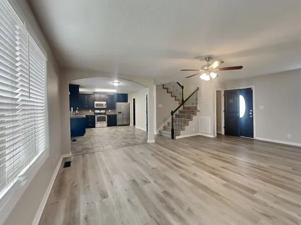 a view of a livingroom with wooden floor and stairs