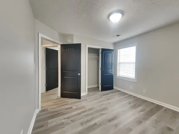 an empty room with closet and windows