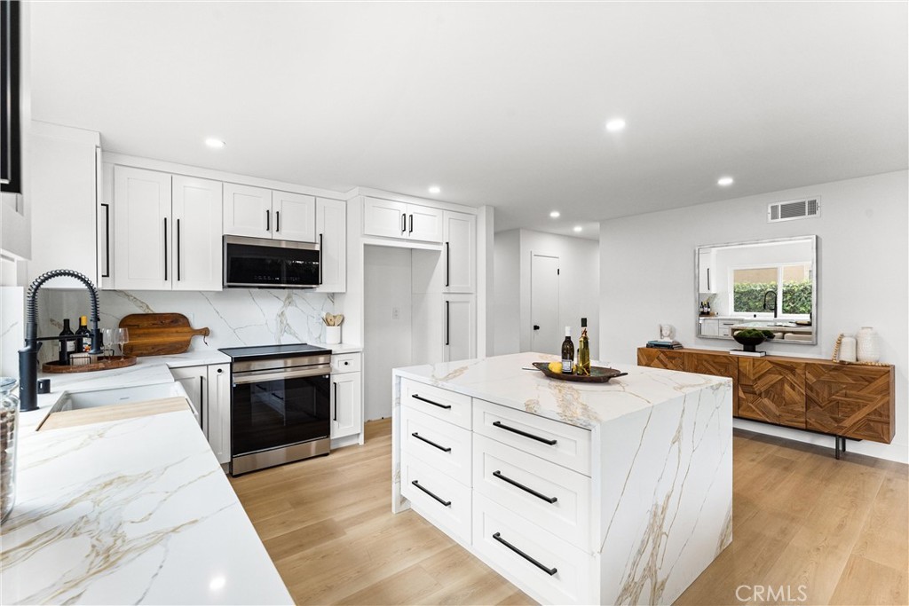 3621 Myrtle Street Irvine, CA 92606 - Photo 17 of 40 a kitchen with stainless steel appliances kitchen island granite countertop a stove and a sink