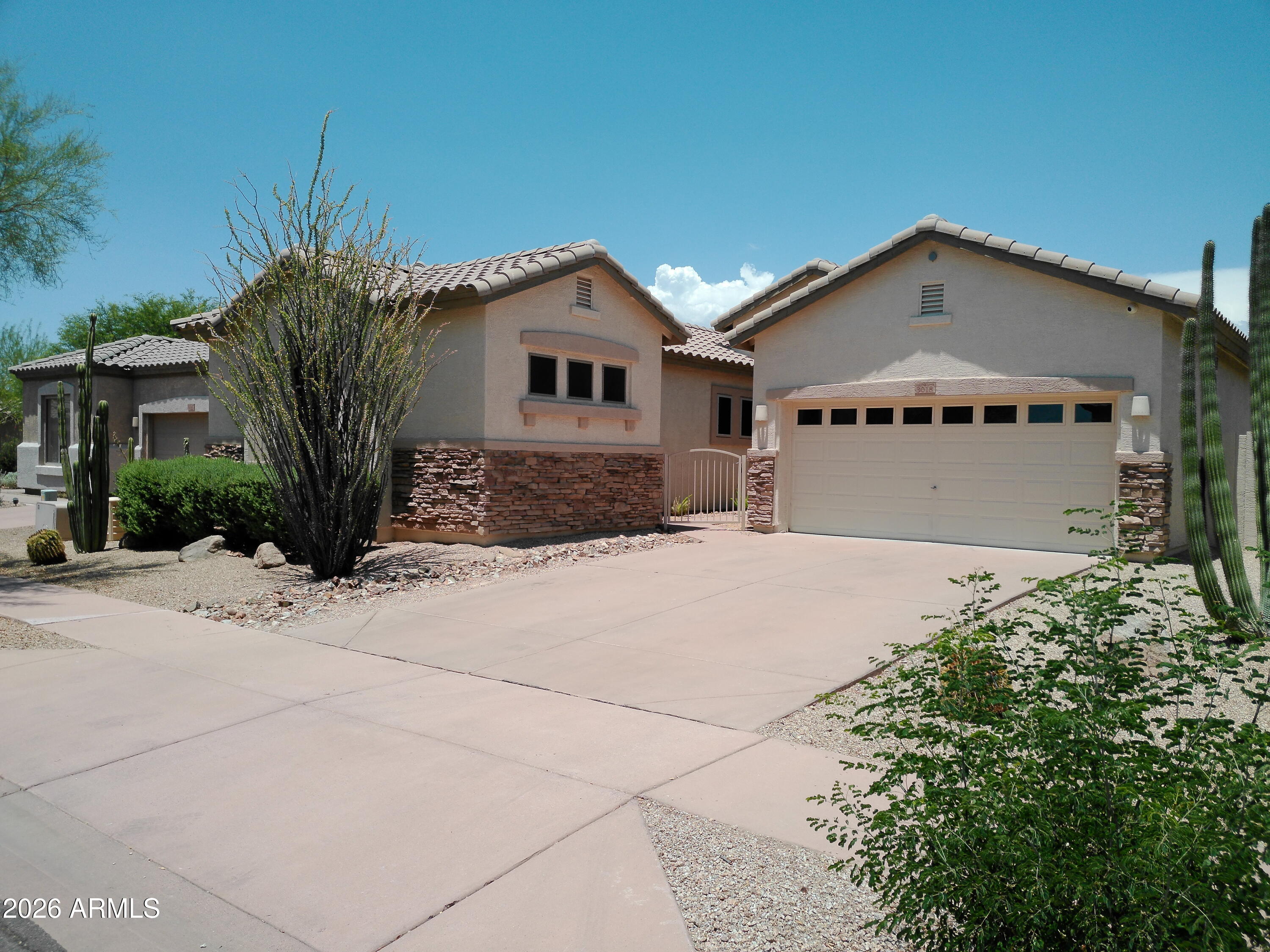 3018 West Sentinel Rock Road Phoenix, AZ 85086 - Photo 4 of 16 a front view of a house with a yard and garage