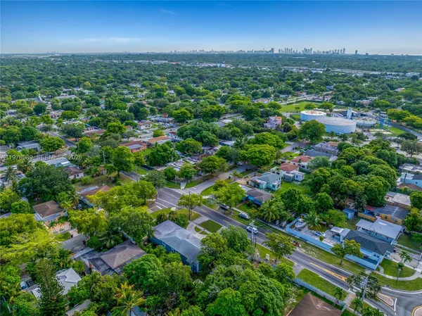 an aerial view of residential houses with outdoor space and trees