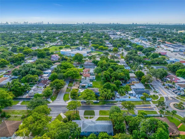 an aerial view of residential houses with outdoor space and trees